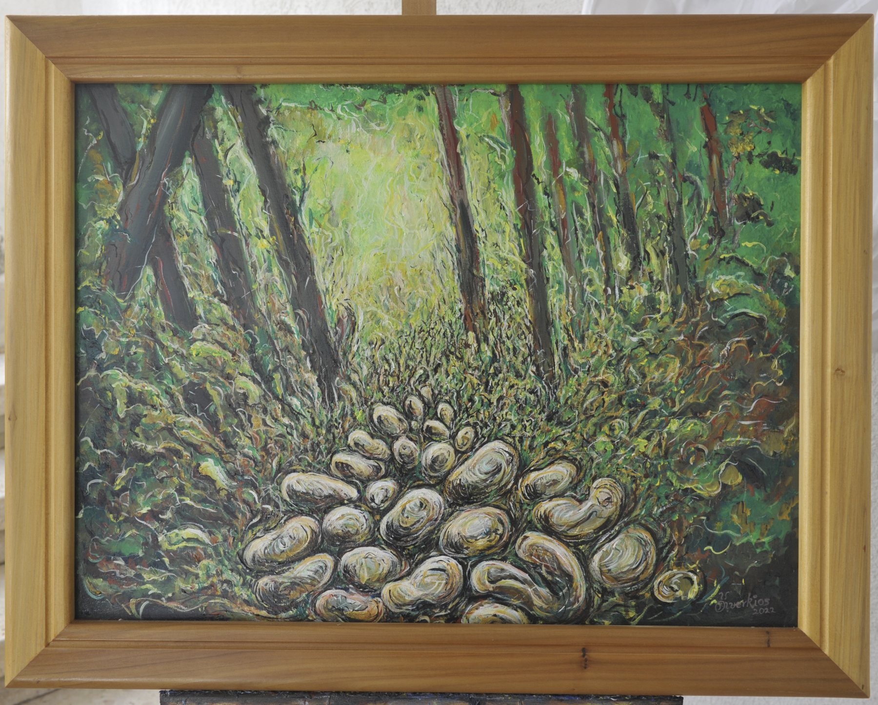 Landscape-format painting of a stone path among vertical tree trunks and dense foliage in green, brown and beige, in a wooden frame