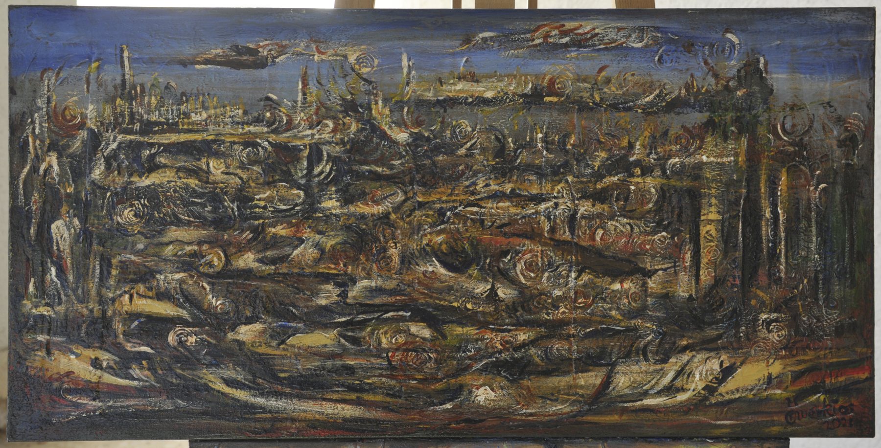 Wide landscape abstract painting with concentric spiral marks, horizontal striations and pillar-like formations in earth tones beneath a strip of blue