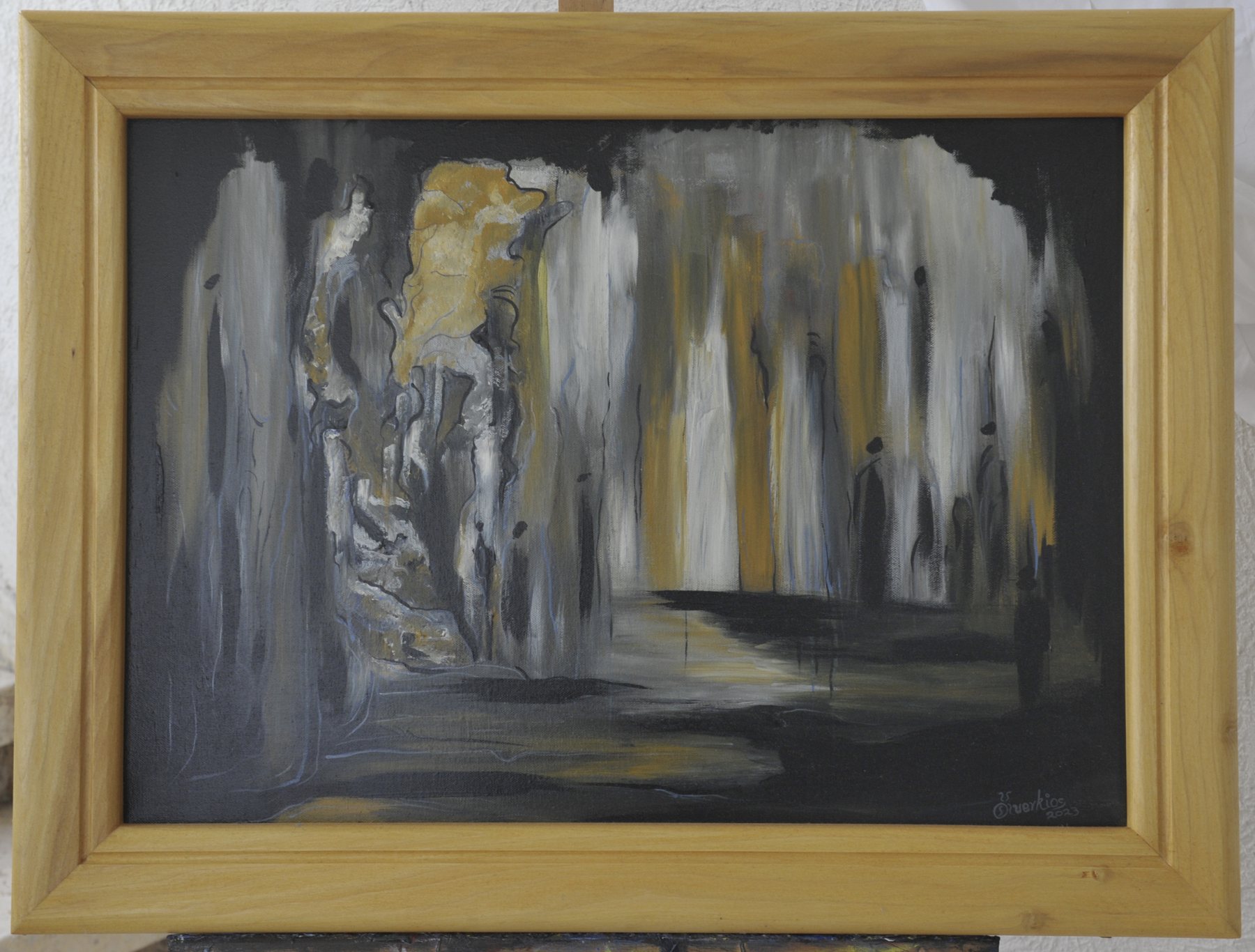 Landscape-format abstract painting with vertical column-like streaks and cavernous shapes in black, grey, white and ochre, in a wooden frame