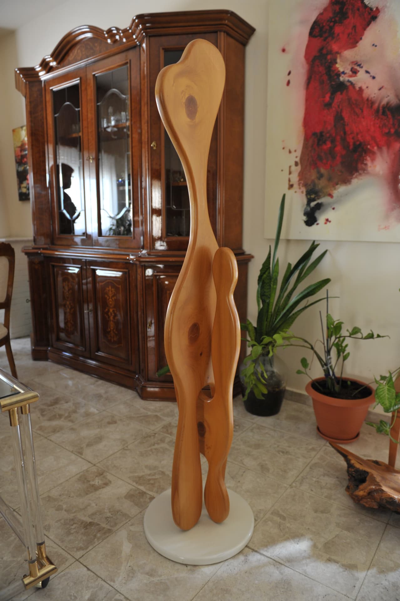 Tall smooth wood sculpture with elongated curves and open spaces