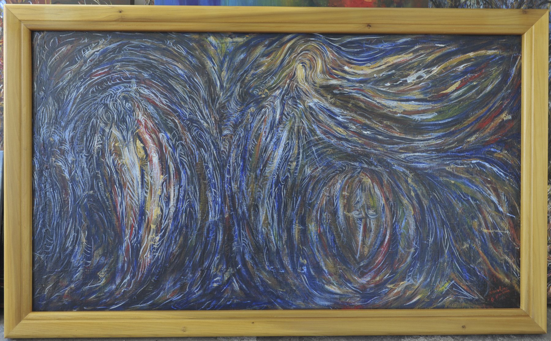 Landscape-format abstract painting with sweeping curved lines and oval vortex shapes in dark blue, white and ochre, in a wooden frame