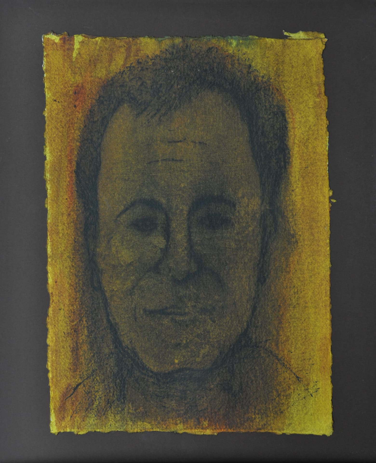 Frontal portrait of a man in dark charcoal over an amber and yellow wash, on deckle-edged paper mounted on a dark grey mat