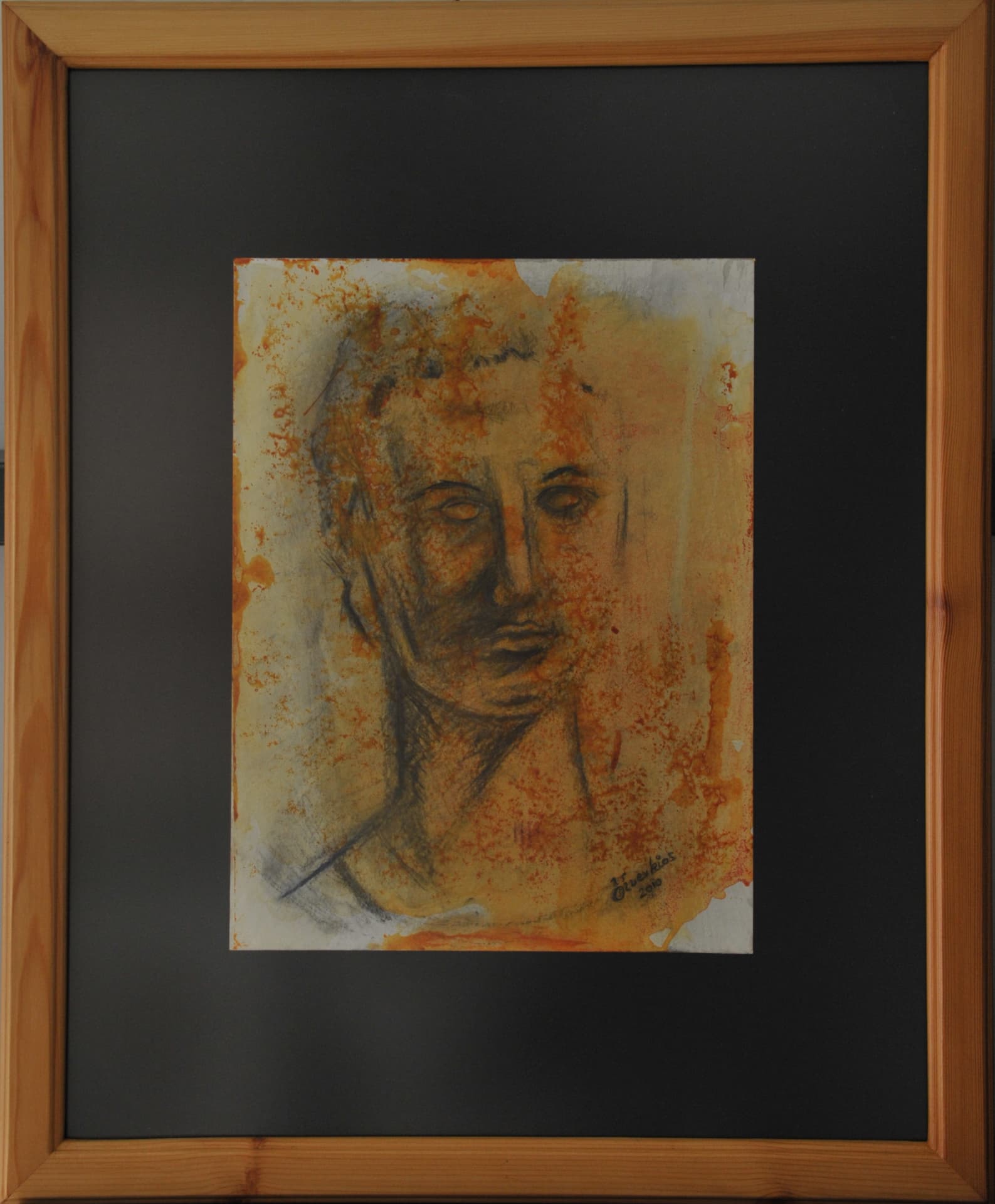 Head and neck of a figure turned slightly toward the viewer, in charcoal line with rust-orange and amber wash, on paper mounted on a black mat in a light wood frame