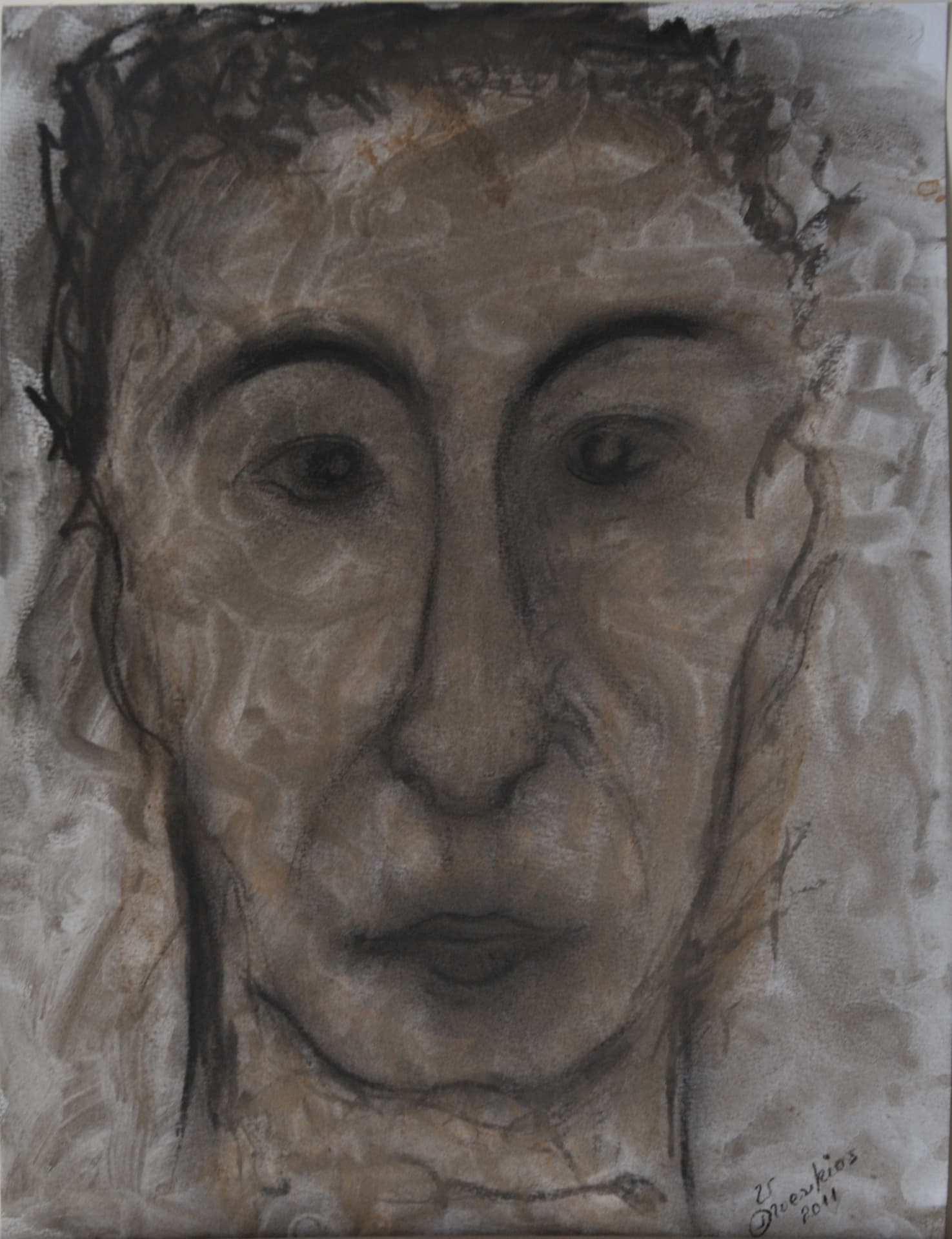 Frontal face with expressive eyes in charcoal and grey washes with traces of orange, on paper