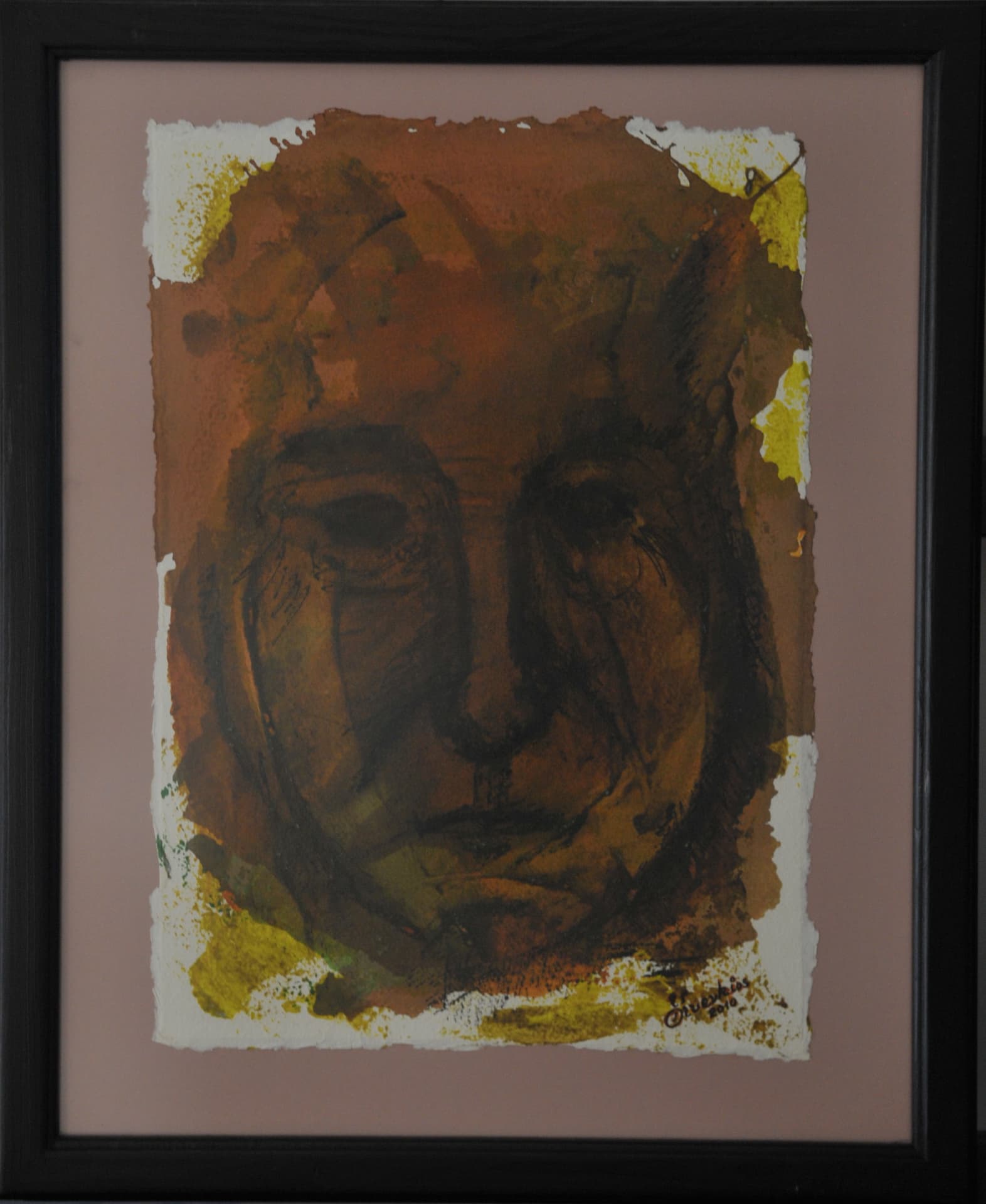 Frontal face in dark drawn lines over terracotta wash with ochre pigment dabs at the edges, on deckle-edged paper mounted on a dusty rose mat