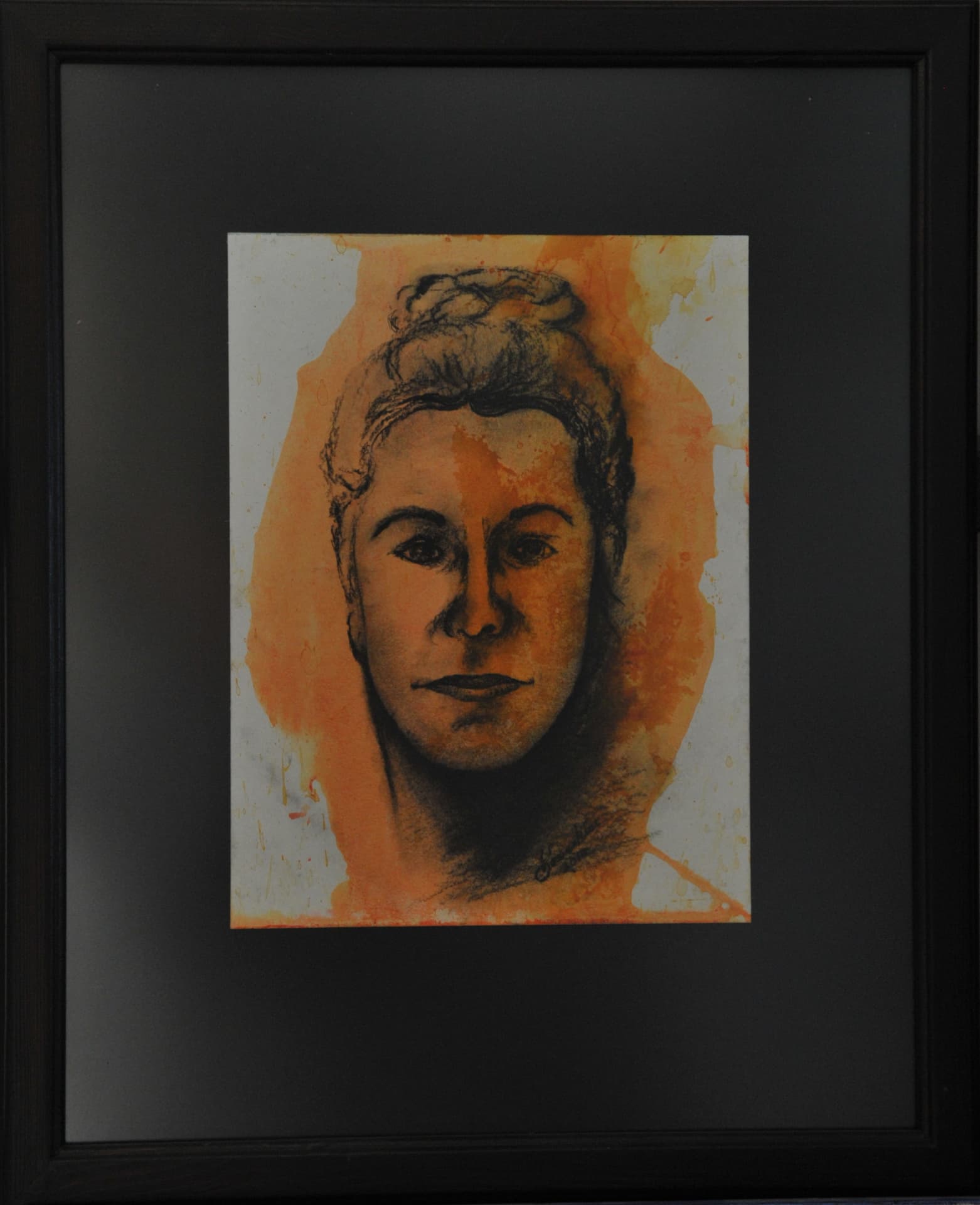 Frontal portrait with hair gathered into a high bun, in blended charcoal over an amber wash with dripping edges, on paper mounted on a black mat