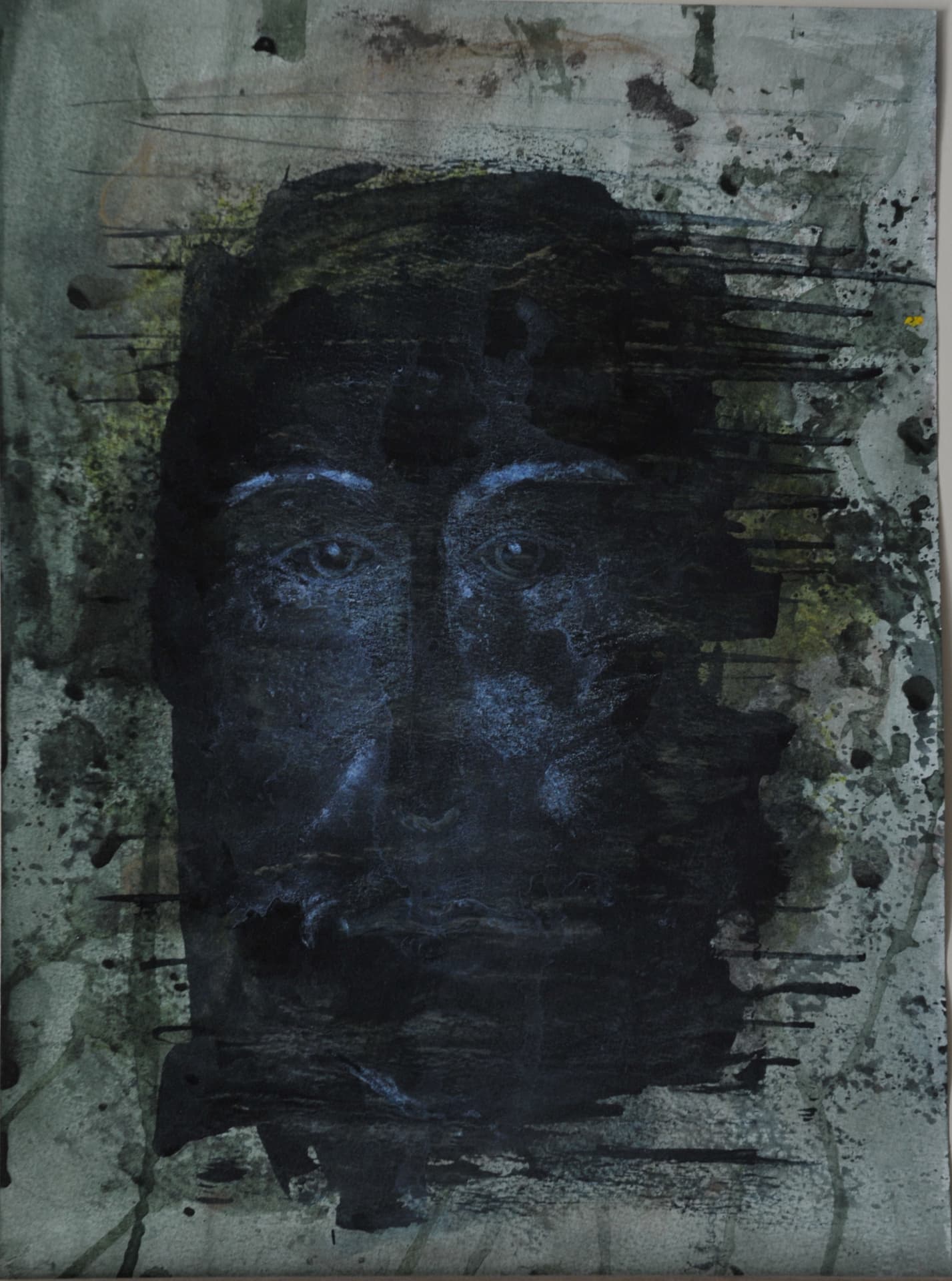 Dark face with pale blue-lit eyes amid black ink strokes and green-grey splatters on grey paper