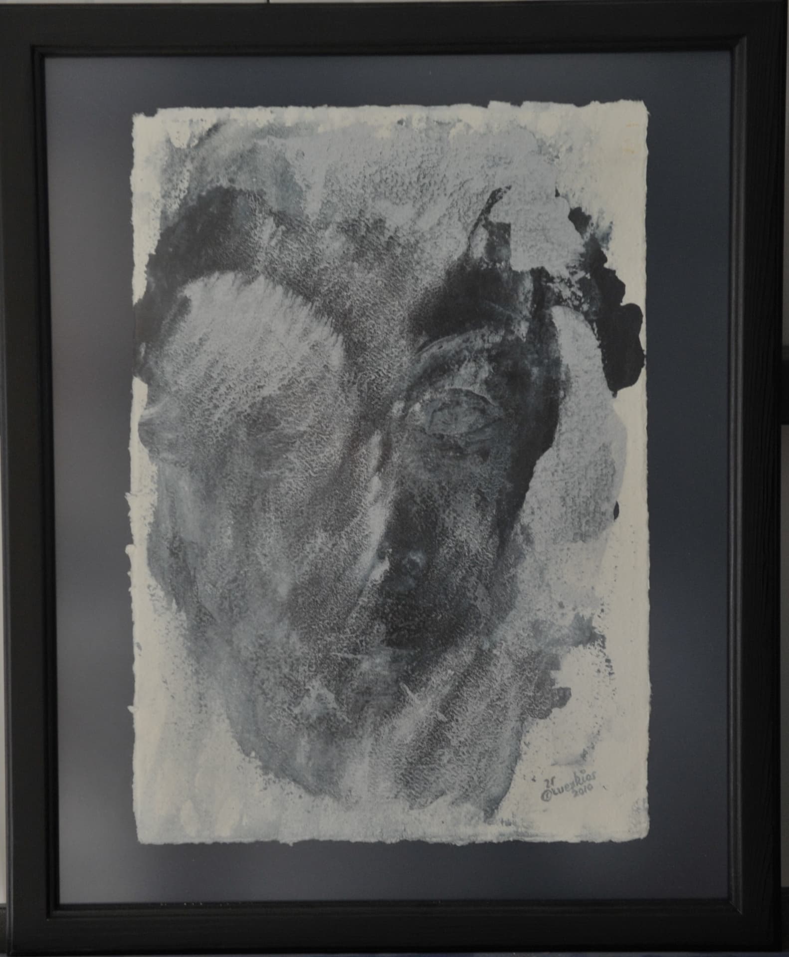 Shadowy impression of a head in black and grey wash on deckle-edged paper, mounted on a slate-grey mat