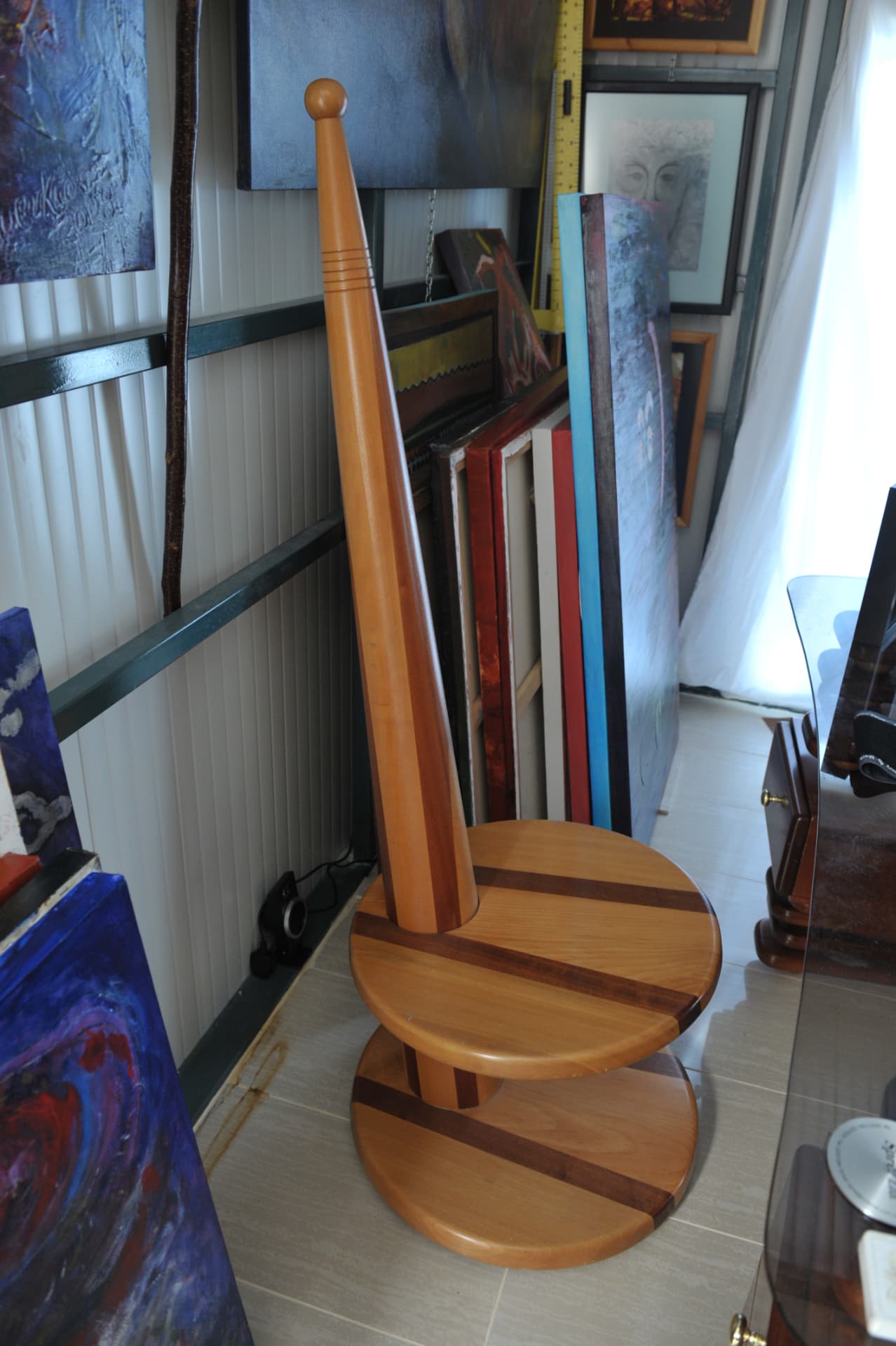 Tall two-tiered wood stand with a tapered column and carved knob, inlaid with bands of pale and reddish wood