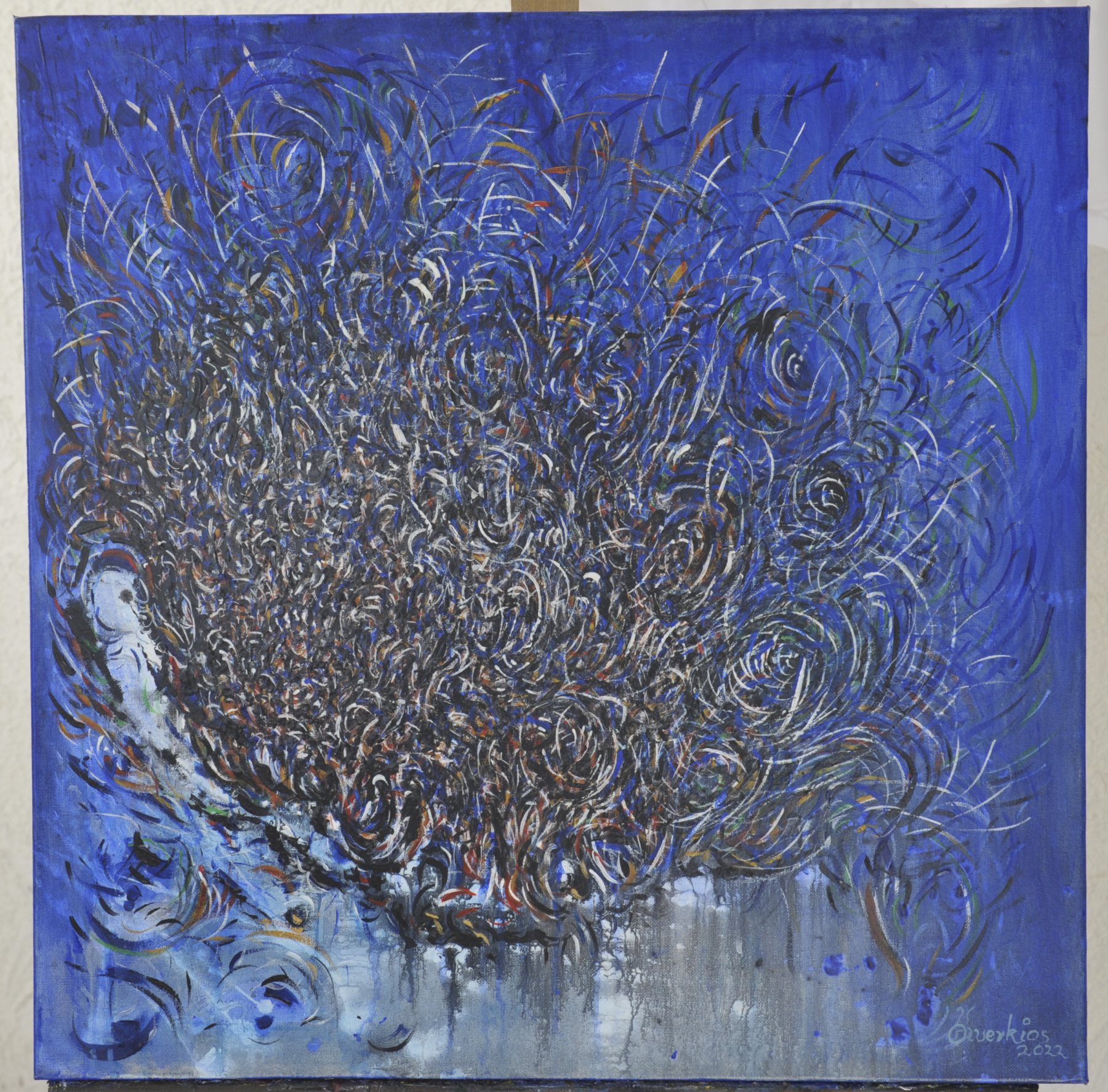 Abstract painting with a dense circular cluster of fine swirls and dripping paint against a solid blue field