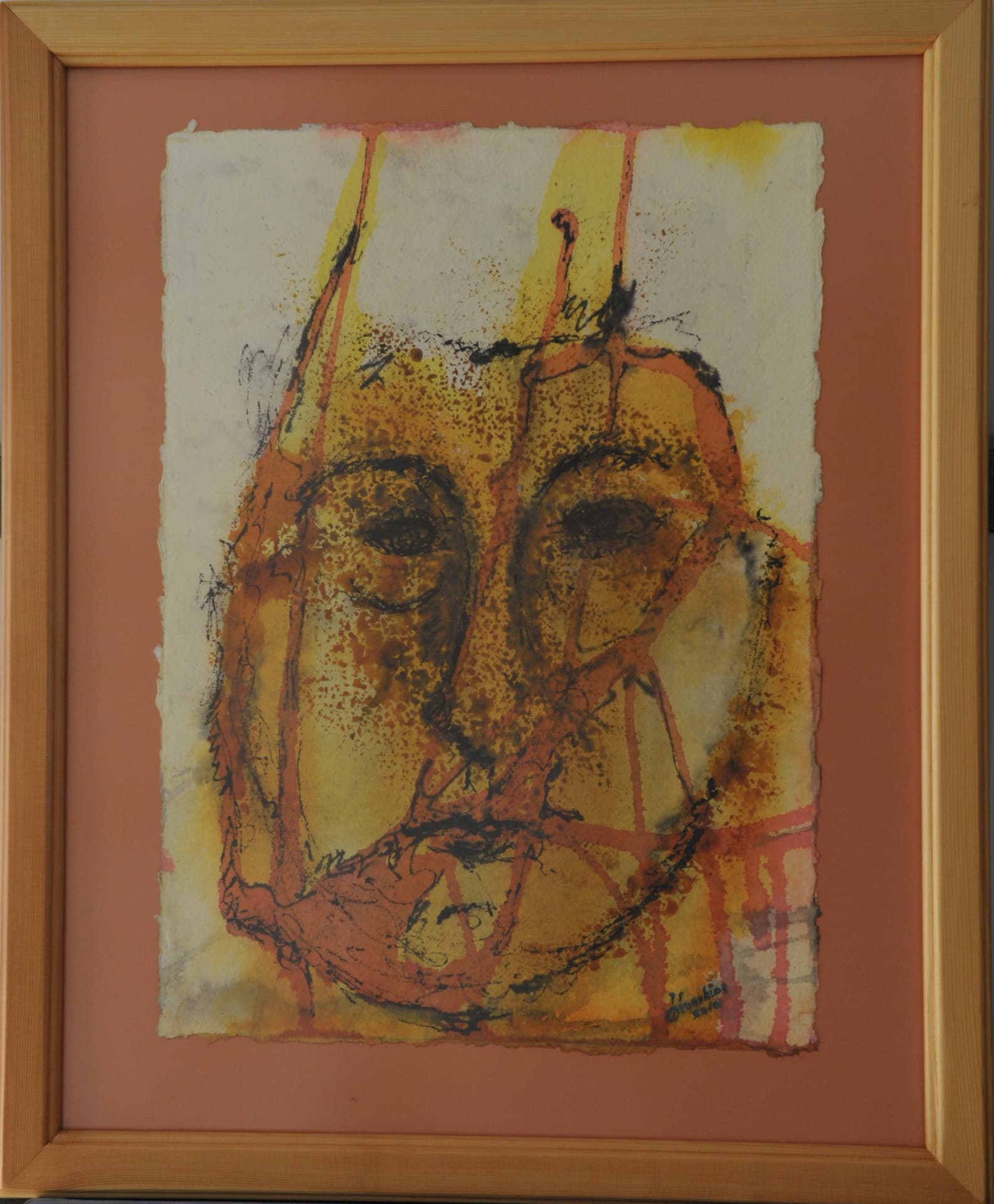 Stylized linear face layered over splashed yellow, ochre and orange wash on paper, mounted on a terracotta mat
